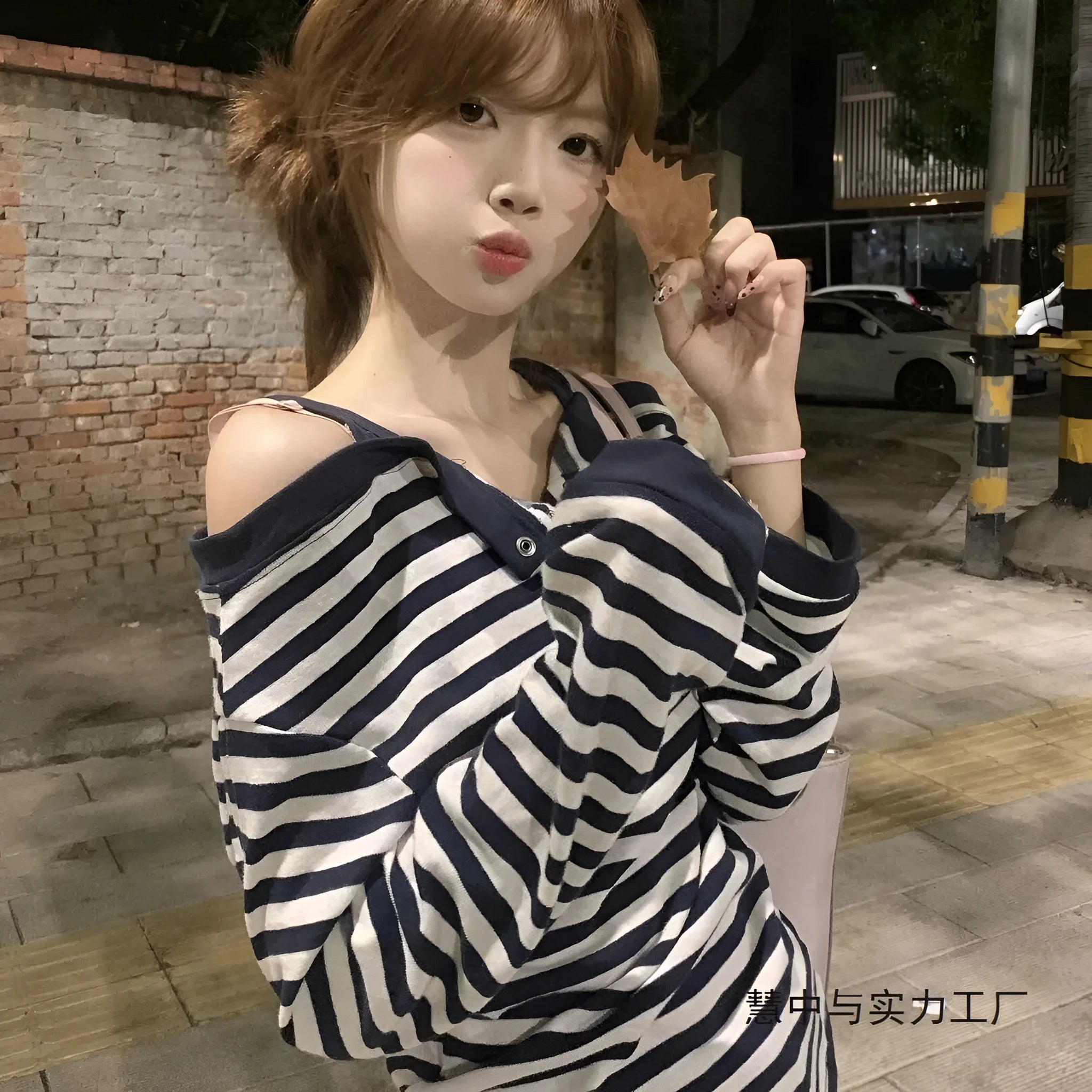 Dark blue Korean-style women's oversized long sleeve t-shirt with stripe and embroidery details on a hanger.