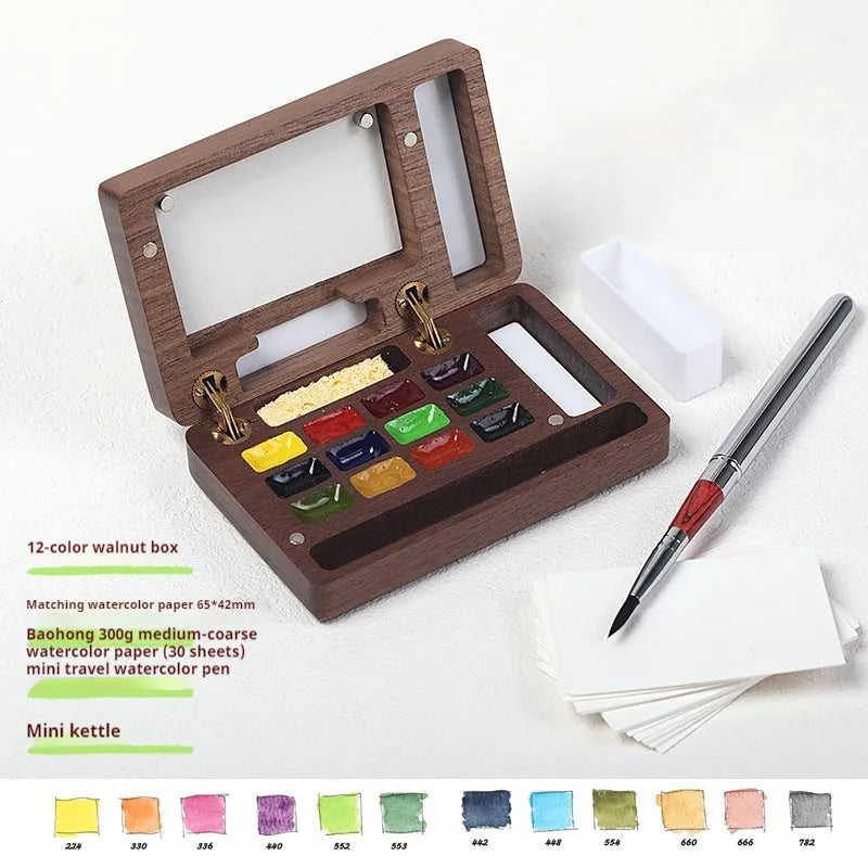 Mini wooden watercolour paint box open showing professional pigment compartments with carrying handle