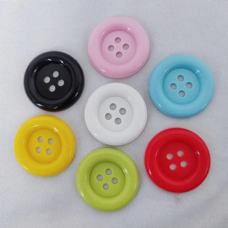 Large round plastic nylon buttons in multiple colours with four sewing holes for garment repair