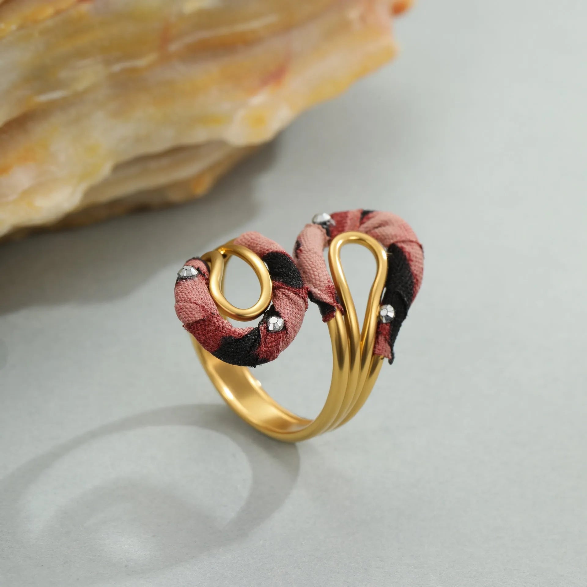 Leopard print geometric open mouth ring on a finger, showing heart shape and adjustable stainless steel band.
