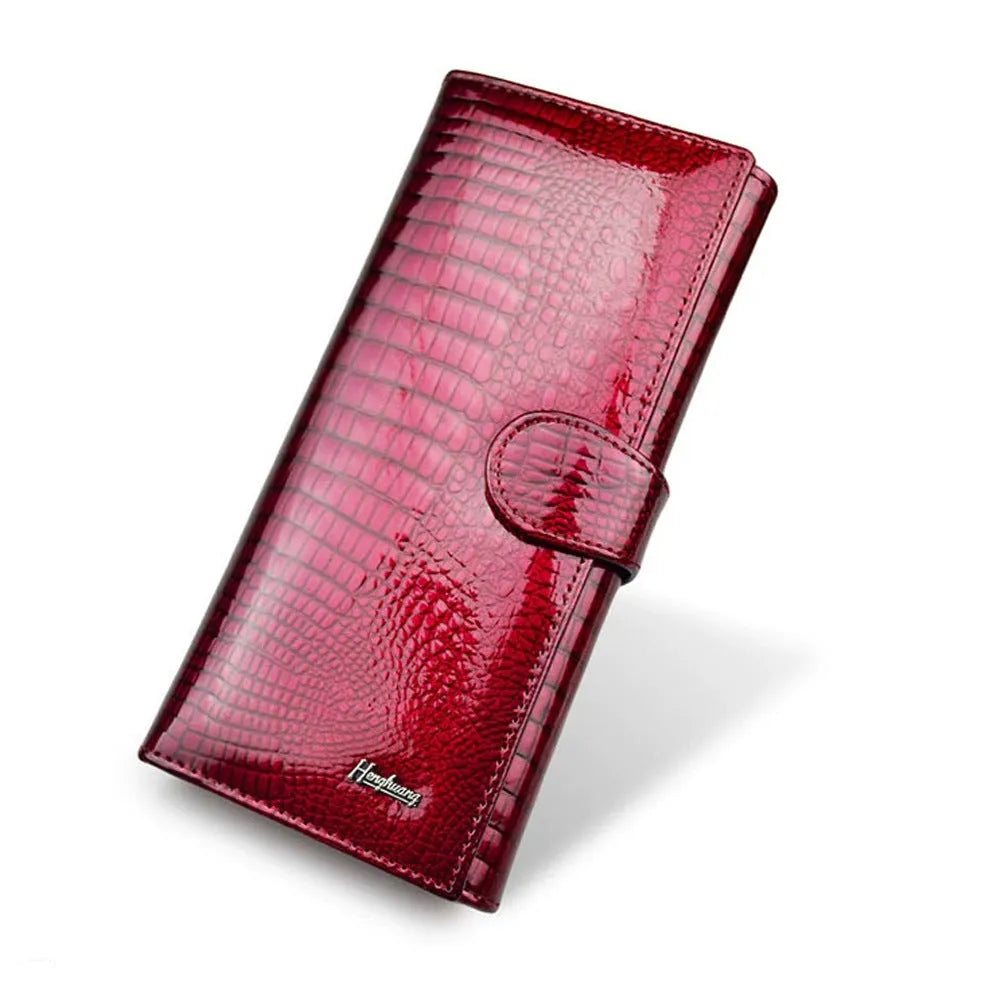 Women's patent leather purse with crocodile pattern in red colour showing pigskin lining interior