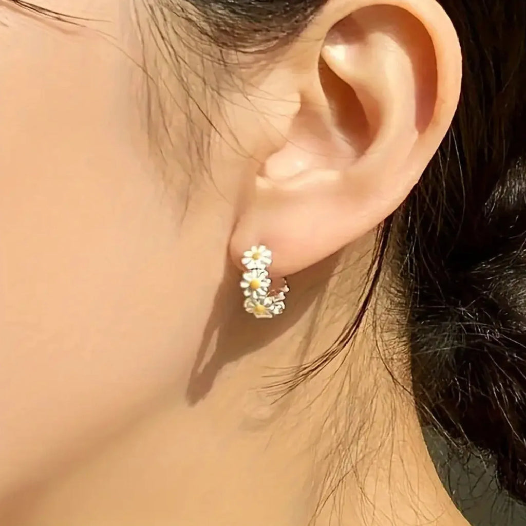 White daisy flower ring earrings with a platinum-colour gem setting.