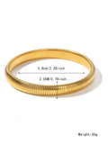 A gold women's elastic titanium steel bracelet with an exaggerated vertical stripe ring design, shown laid flat.
