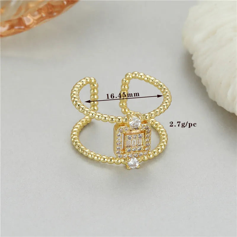 Gold-coloured adjustable open ring with an asymmetric U-shaped design on a plain background.