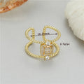 Gold-coloured adjustable open ring with an asymmetric U-shaped design on a plain background.