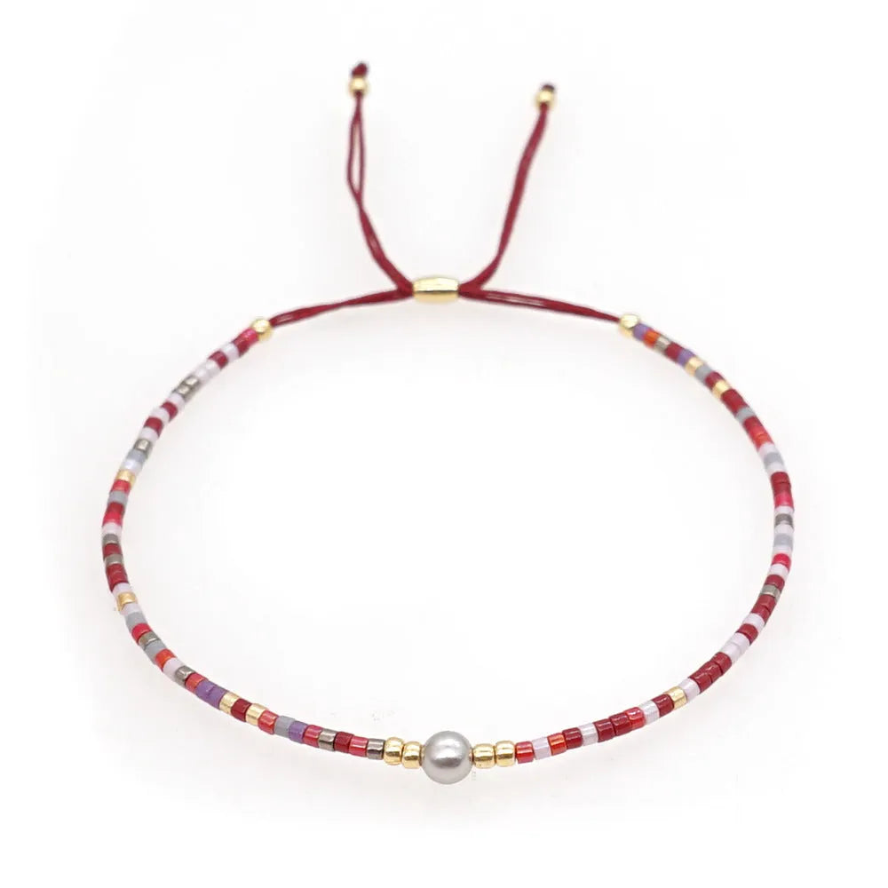 Handmade Bohemian-style women's bracelet with semi-precious stone and colourful glass beads on a wrist.