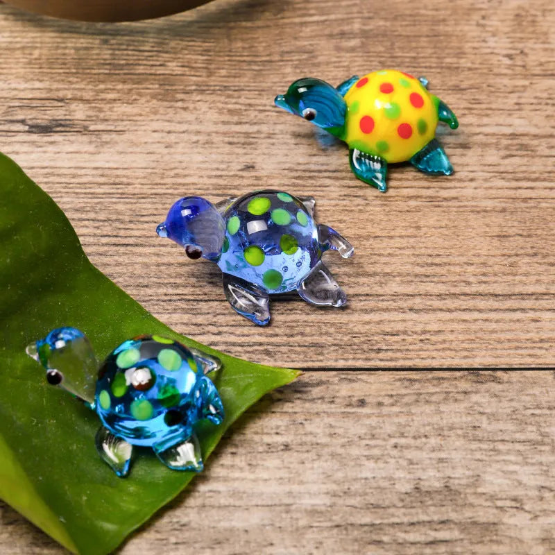 Geometric glass turtle ornament in a blue head and blue shell colour variant on a desktop.