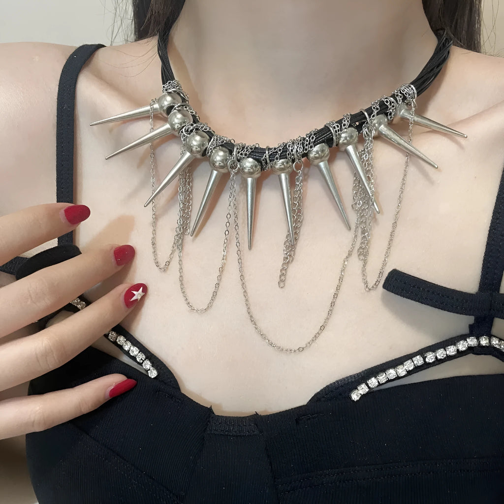 Leather necklace with winding round beads, metallic rivet details, and a long tassel in an electroplated finish.