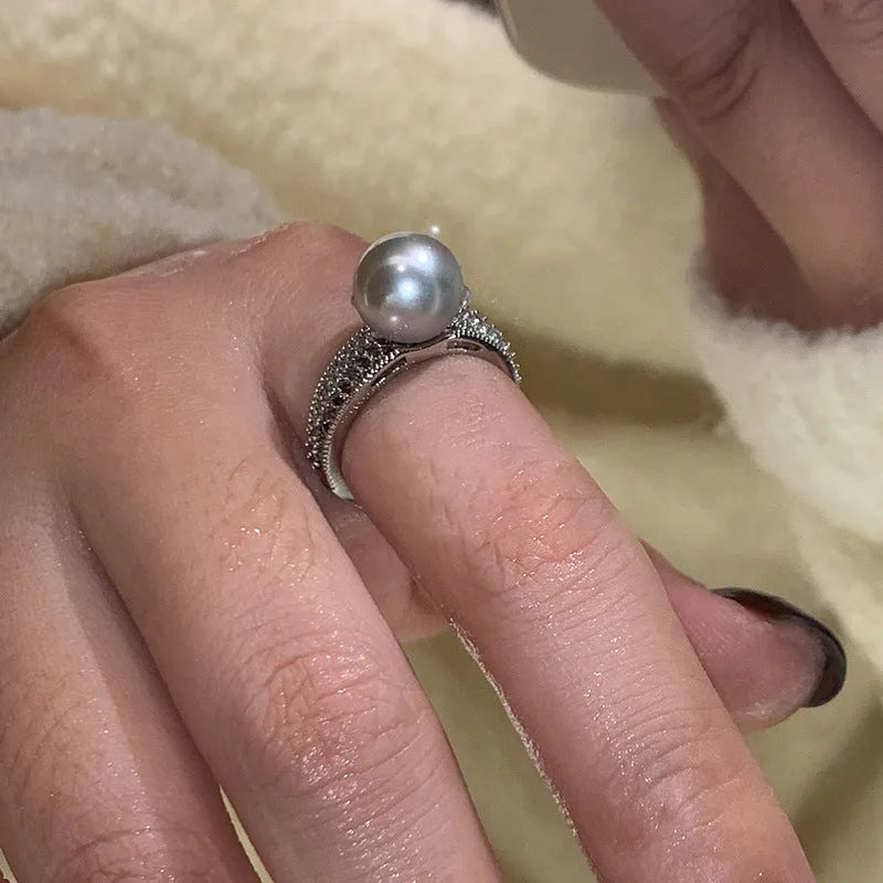 Geometric black pearl open finger ring with adjustable copper construction on female hand