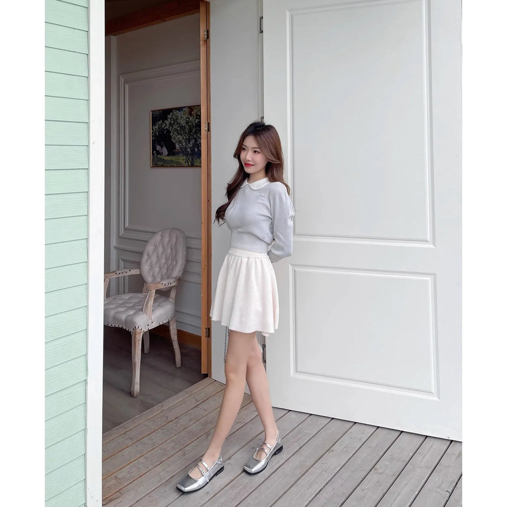 Women's silver leather Mary Jane flats with a cross-buckle strap and round toe.