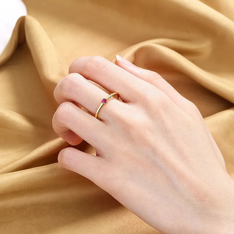 A simple single diamond fine circle ring for women in copper, shown in blue, green, red, and white colour options.