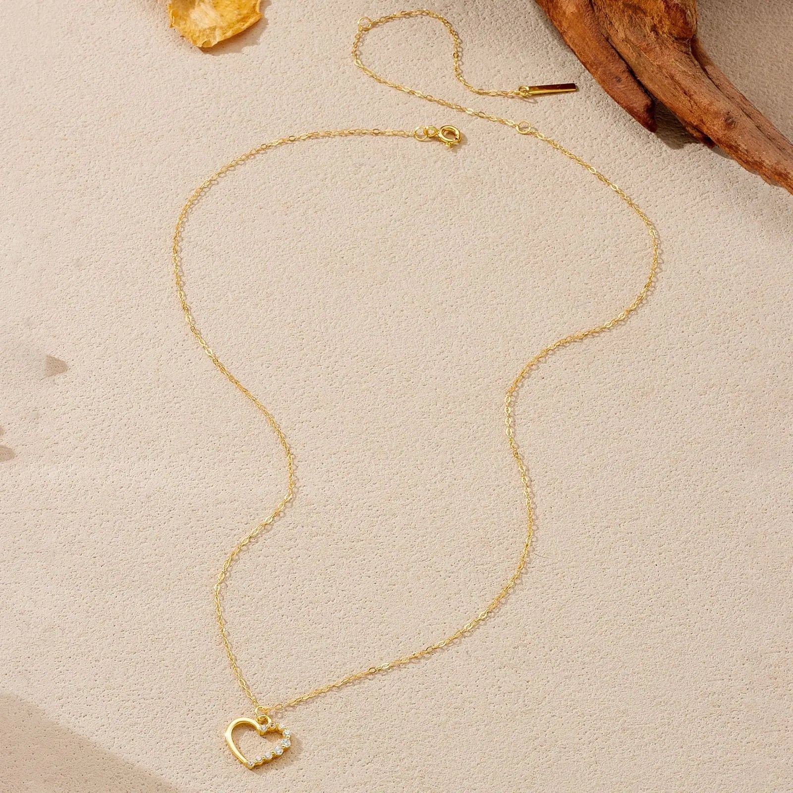 Close-up of a sterling silver hollow heart pendant necklace on a regular chain.