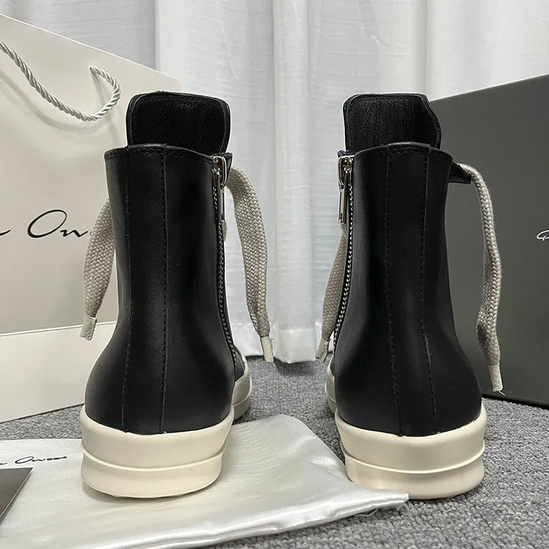 Men's and women's black high-top leather shoes with a side zipper and visible stitching on a round toe