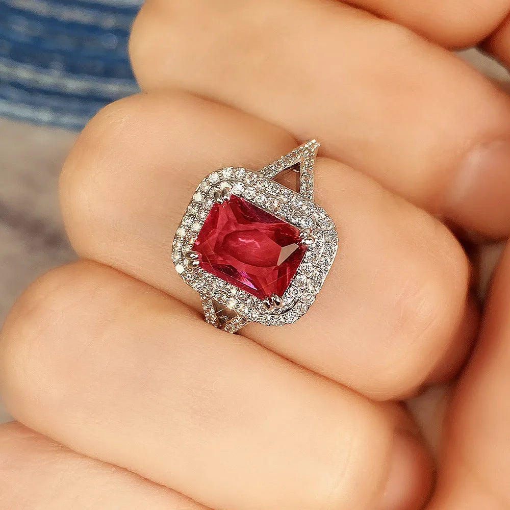 Red geometric square copper ring with clear princess-cut rhinestones, shown on a finger.