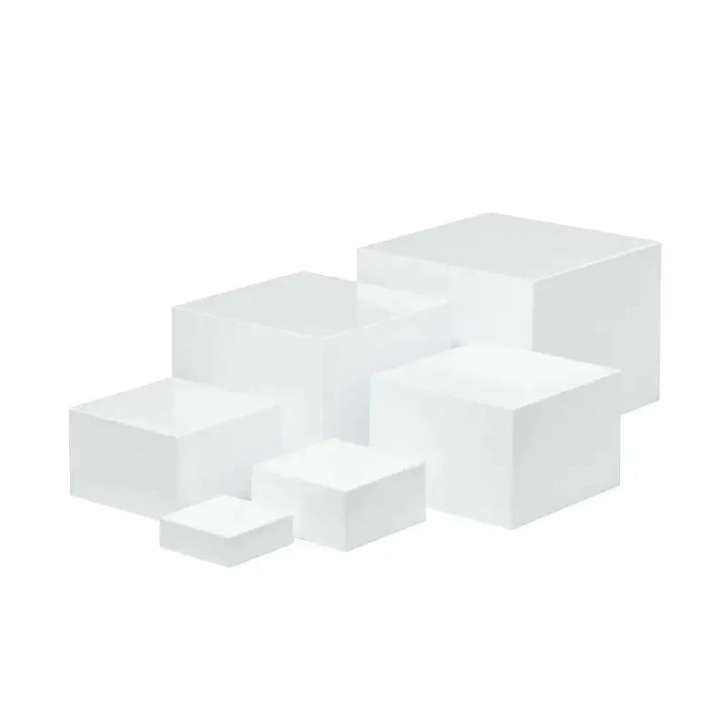 Set of six white plastic cube-shaped dessert display stands arranged on a desktop.