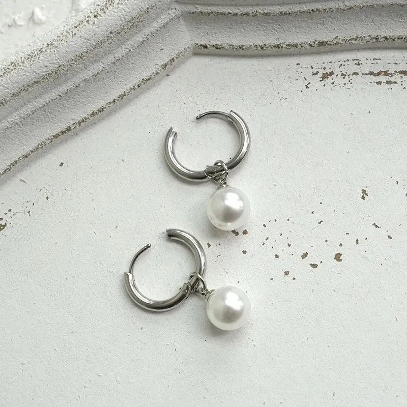 Pair of women's geometric pearl earrings with alloy construction and titanium steel posts