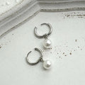 Pair of women's geometric pearl earrings with alloy construction and titanium steel posts
