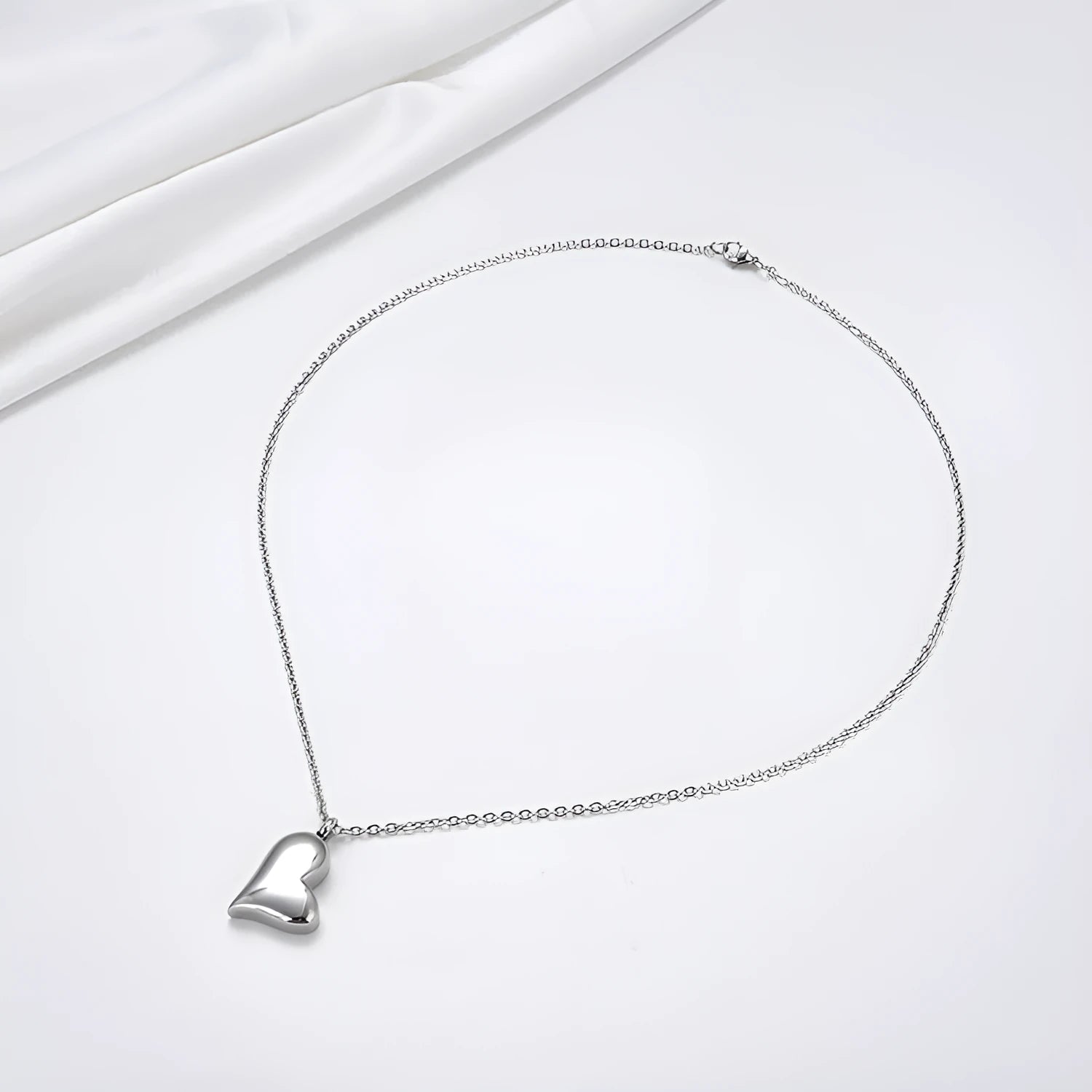 Curved peach heart silver stainless steel pendant necklace on display showing chain and pendant detail