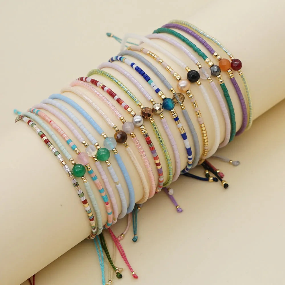 Handmade Bohemian-style women's bracelet with semi-precious stone and colourful glass beads on a wrist.