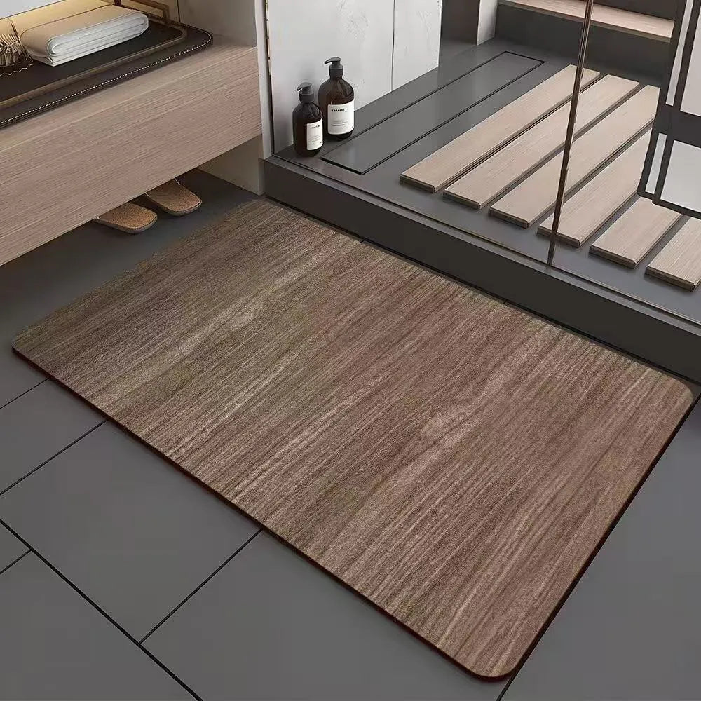 Square diatom mud bathroom floor mat with wood grain geometric pattern in front of a washroom door.