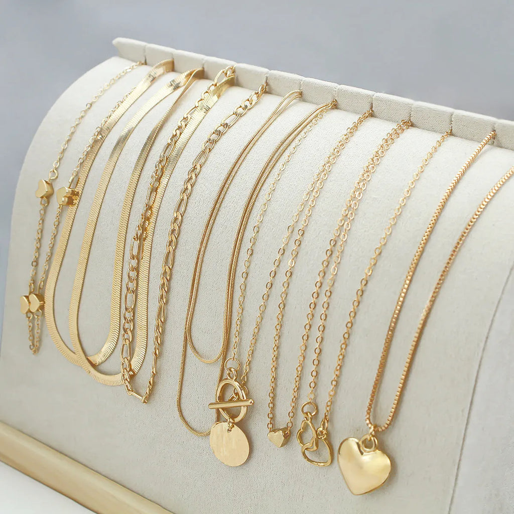 Set of 10 gold electroplated necklaces with alloy pendants on snake bone chains