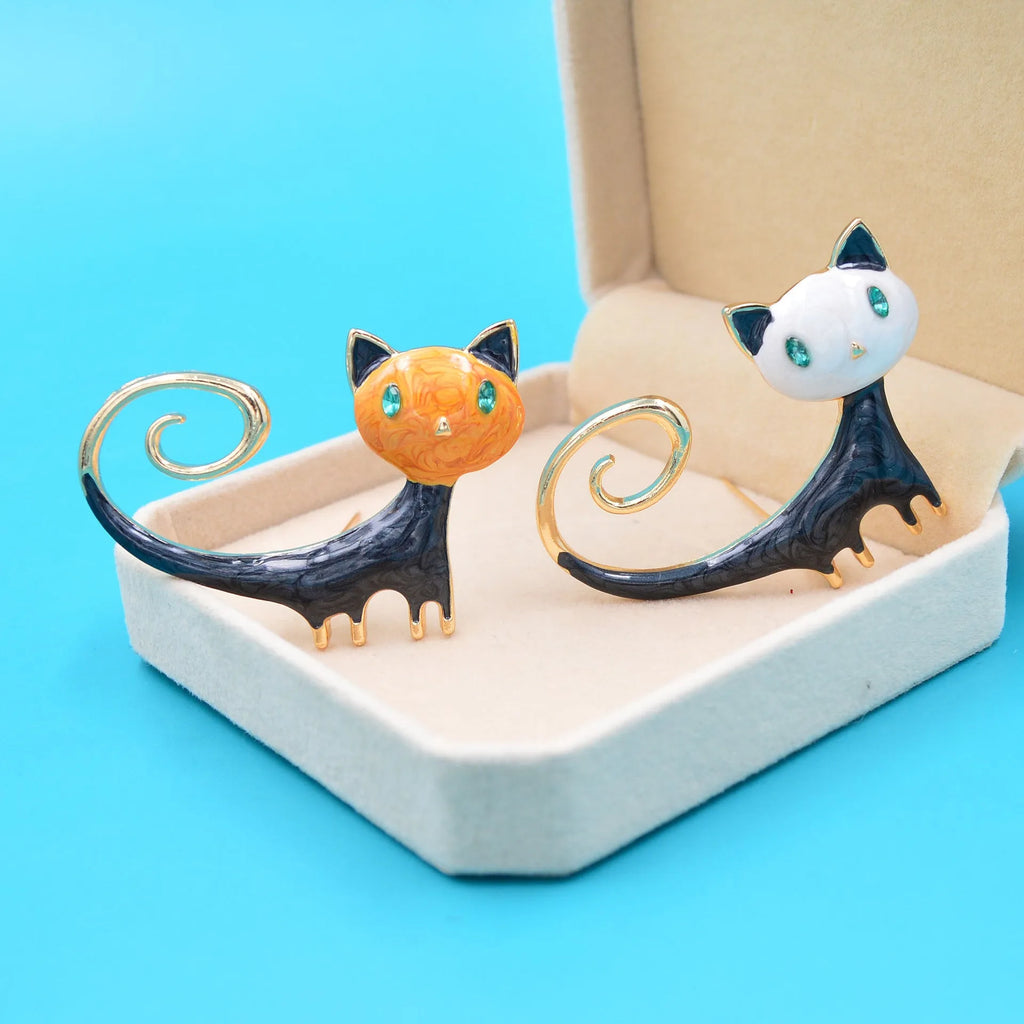 Close-up of an orange painted cat tail brooch made from alloy metal with a pin clasp.
