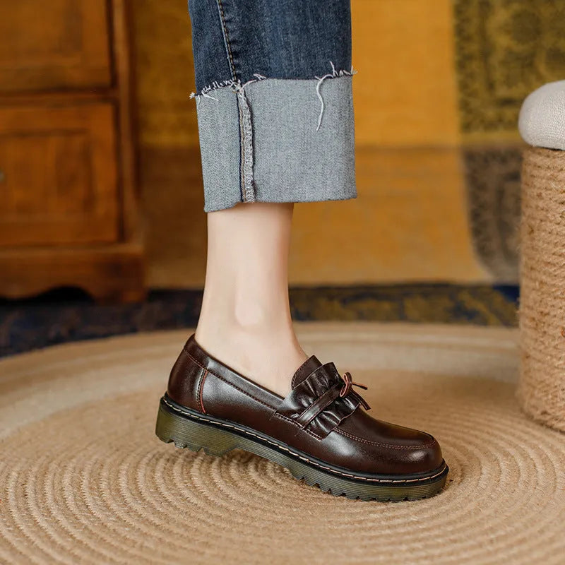 Black British style women's leather shoes with round toe and chunky flat heel on a white background.