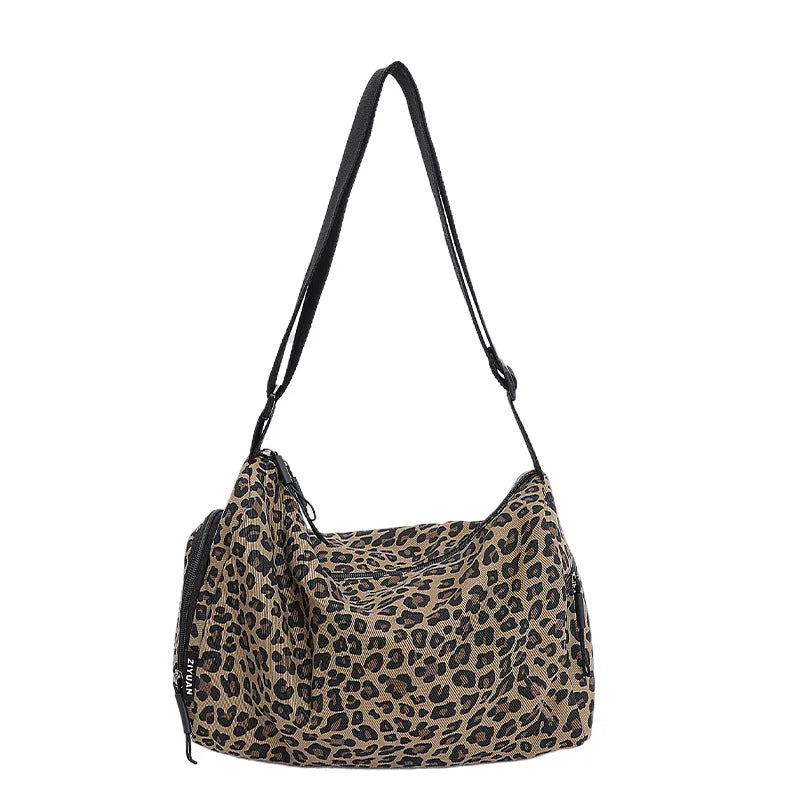 Cloth messenger bag with leopard print pattern showing cross-body strap and stitching details