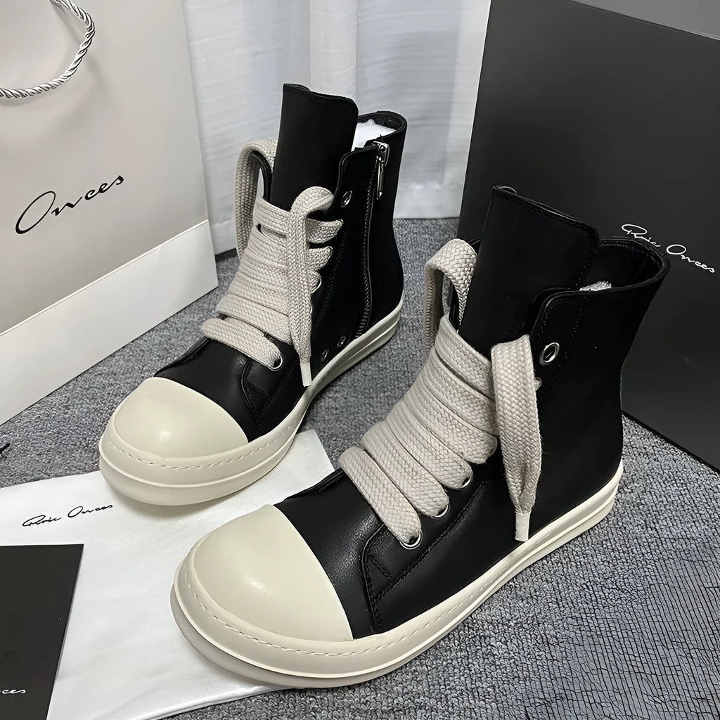 Men's and women's black high-top leather shoes with a side zipper and visible stitching on a round toe