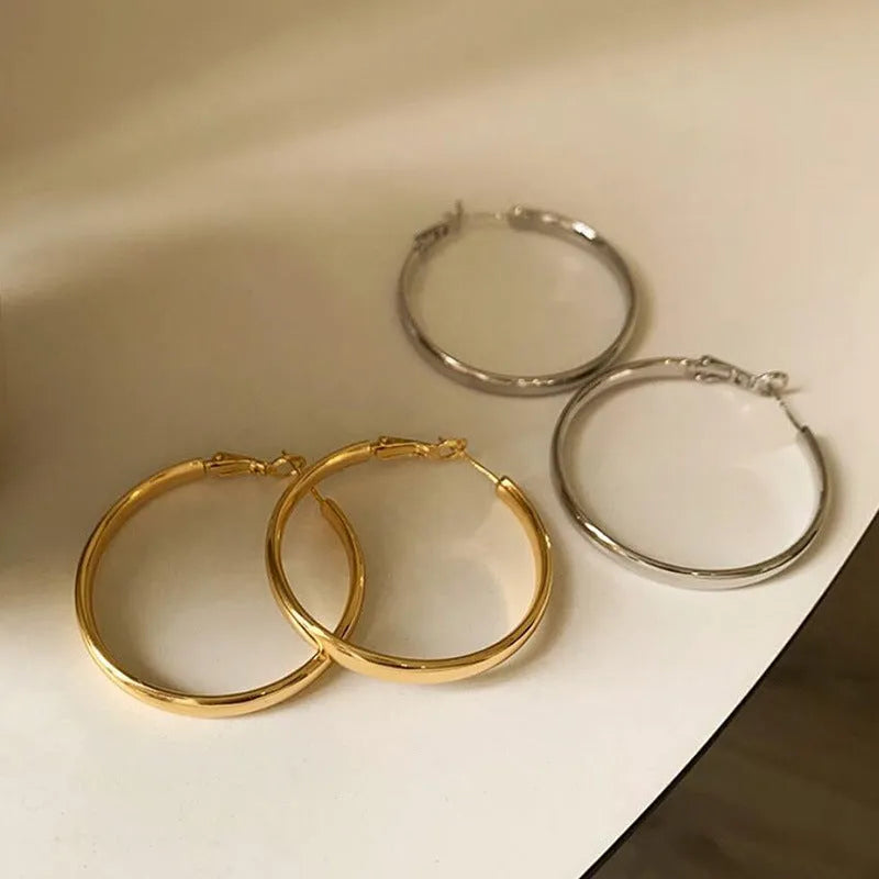 A pair of circular metal earrings with a gold electroplated finish, measuring 40mm.
