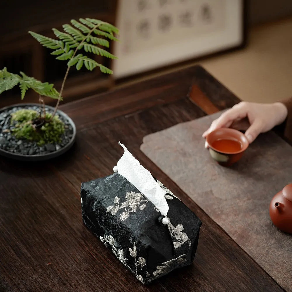 Chinese brocade fabric tissue box with embroidered white plum design, shown with and without a pearl buckle.