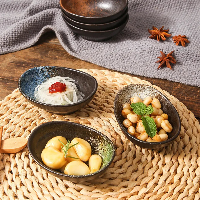 Oval Japanese ceramic sauce dipping bowl with hand-painted Edo pattern design on a table