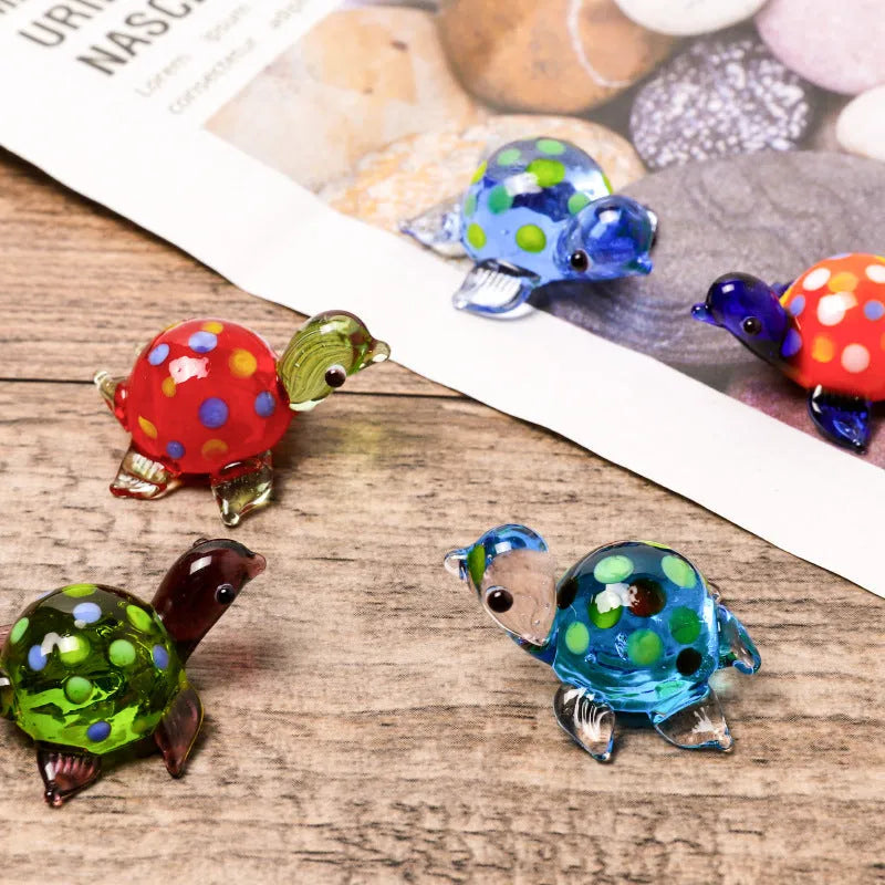 Geometric glass turtle ornament in a blue head and blue shell colour variant on a desktop.