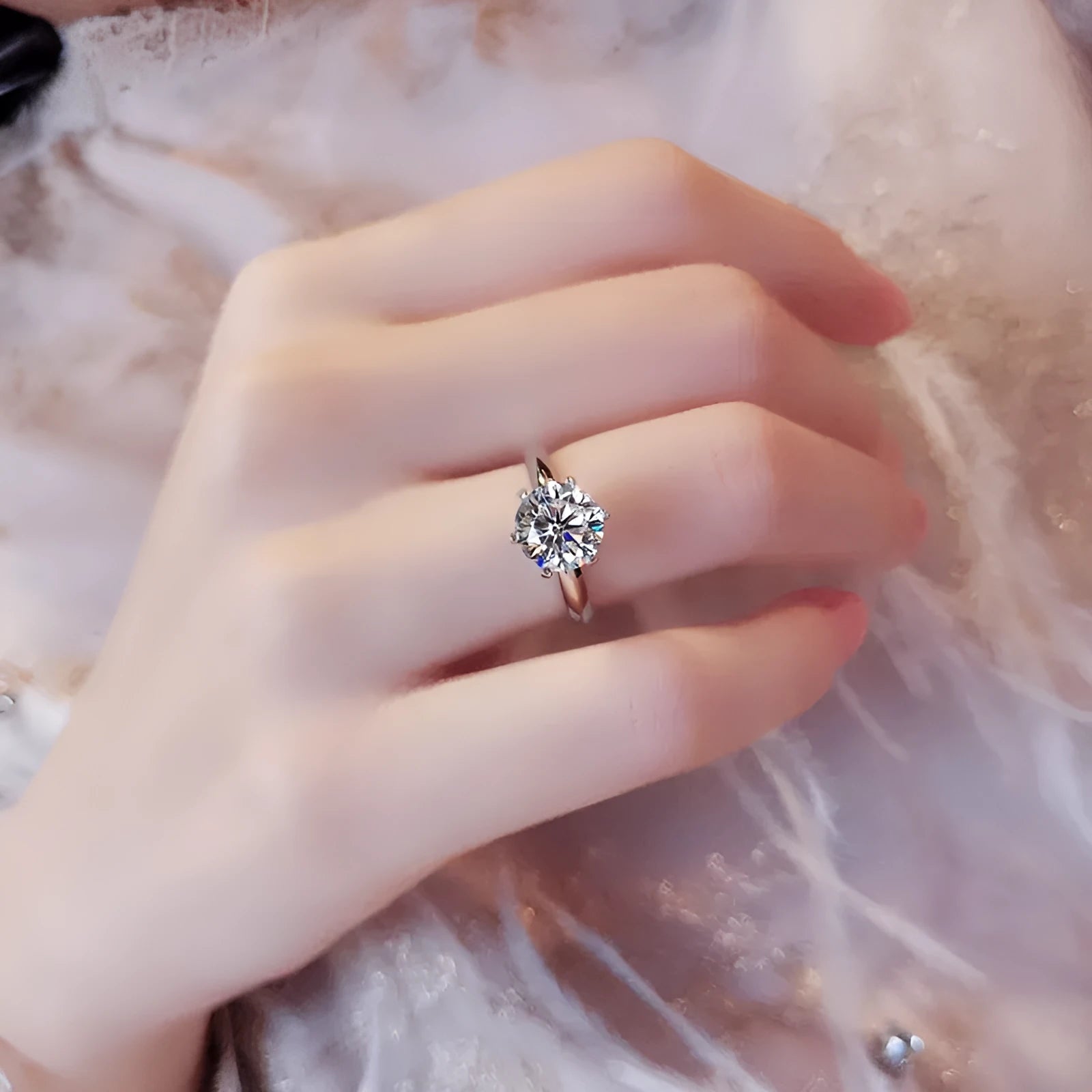 White gold plated geometric ring with a zircon stone in a six-claw setting on a finger.