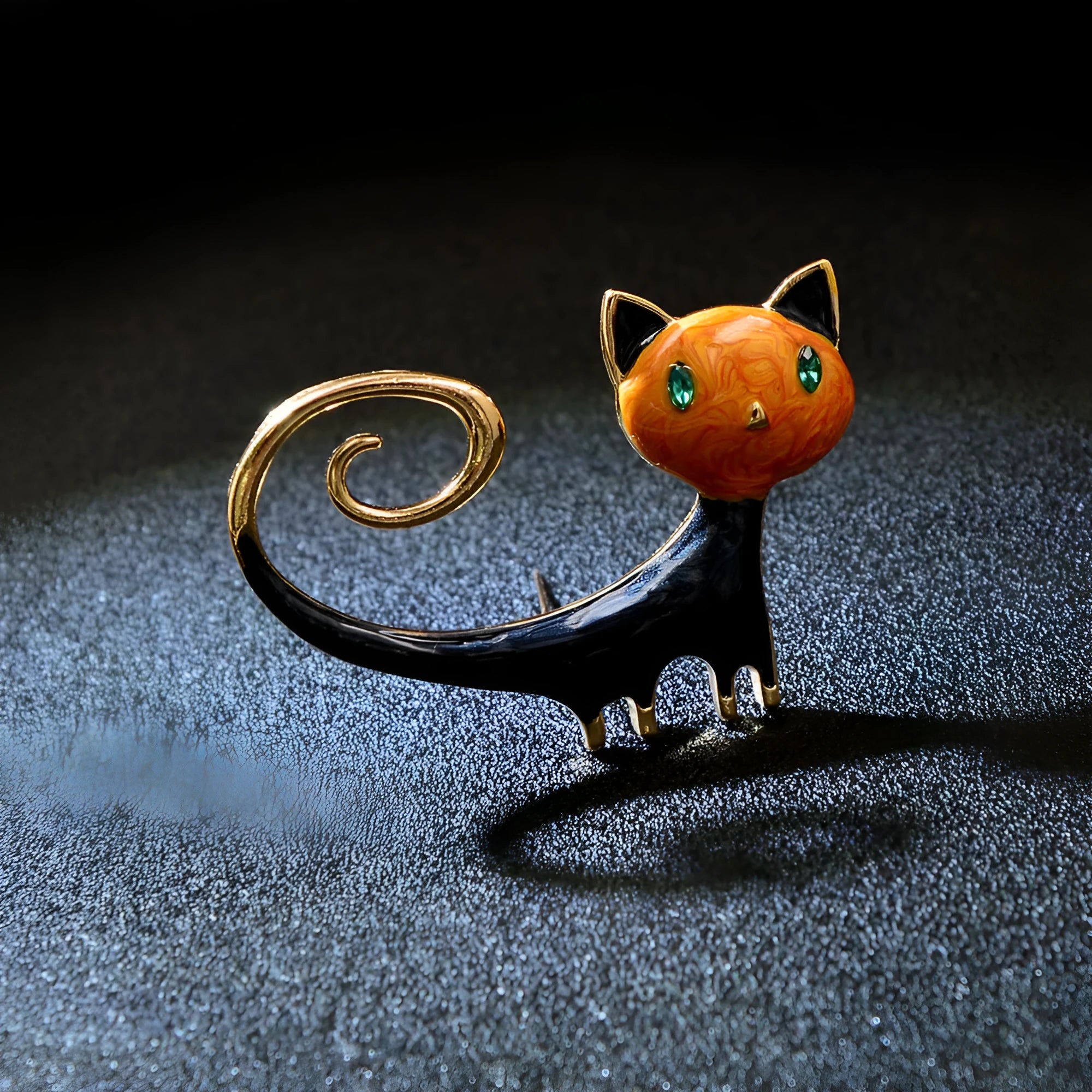 Close-up of an orange painted cat tail brooch made from alloy metal with a pin clasp.