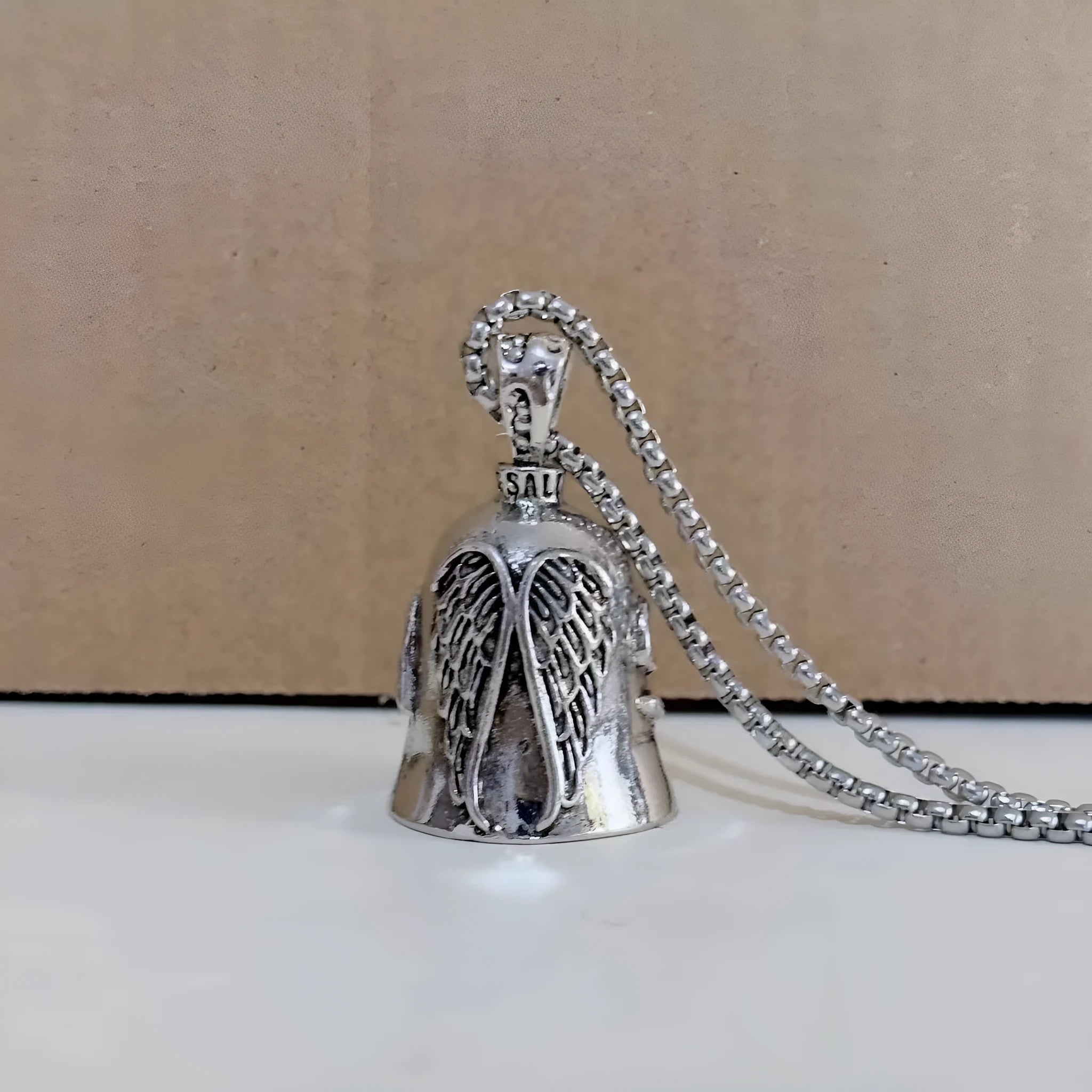 Vintage white angel feather wings alloy keychain and necklace set on a plain background.