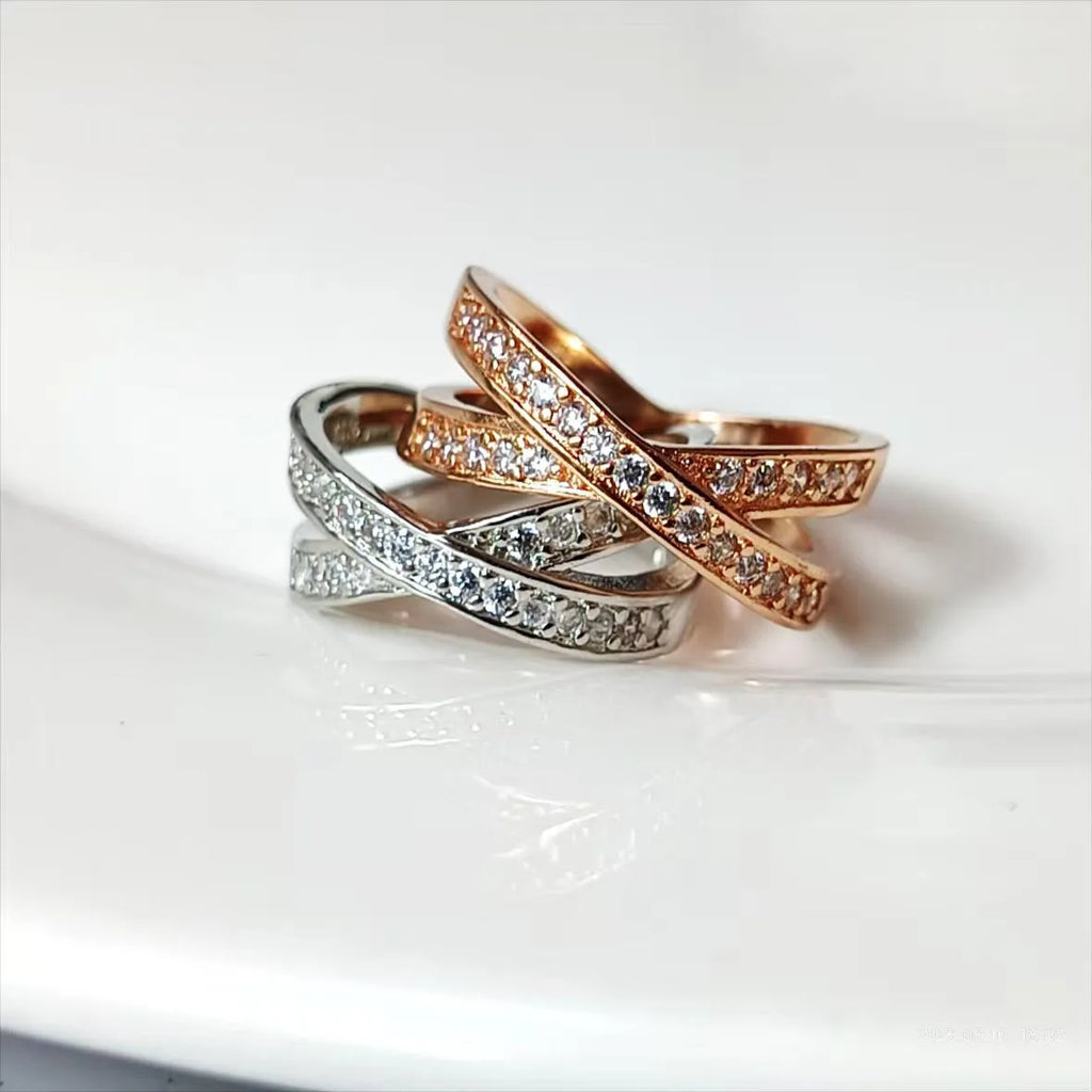 Silver and rose gold metal ring with a small cross design featuring micro-inlaid zircon stones.