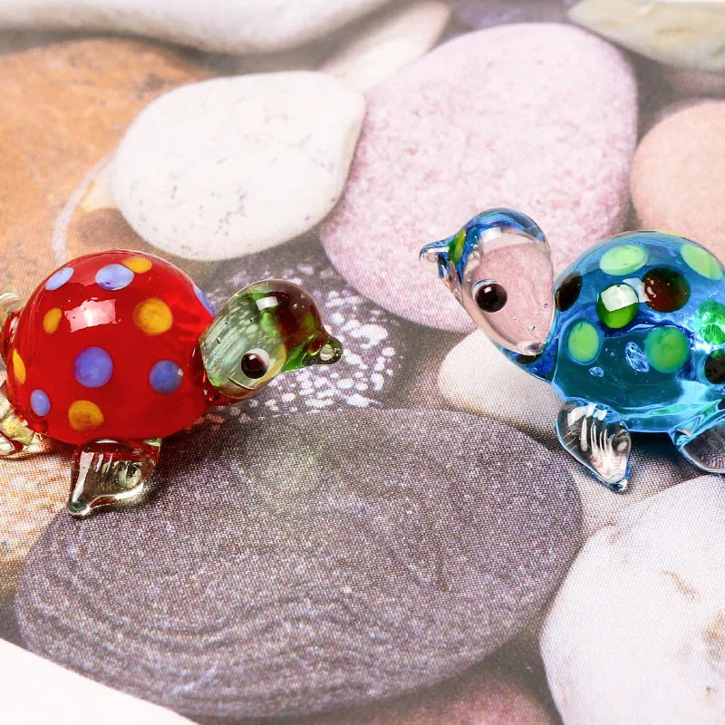 Geometric glass turtle ornament in a blue head and blue shell colour variant on a desktop.