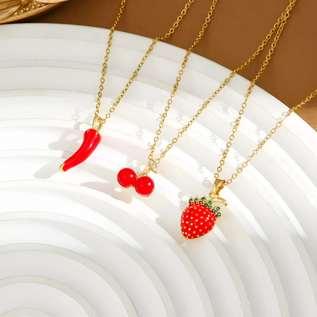 Titanium steel necklace with O-ring chain and a delicate cherry pendant in a gold-tone finish.