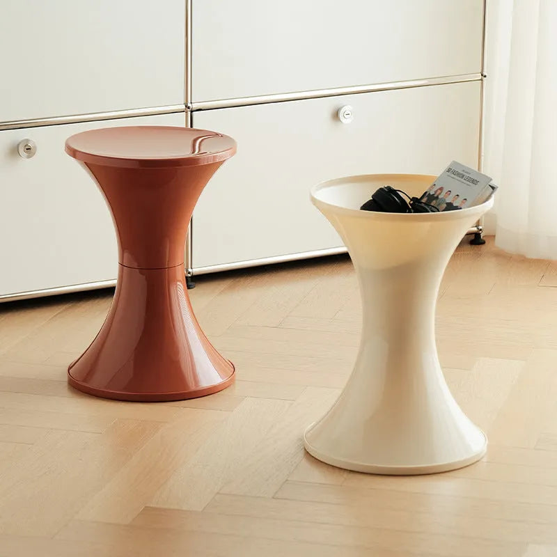 Hourglass-shaped plastic shoe changing stool in green colour on a wooden floor.