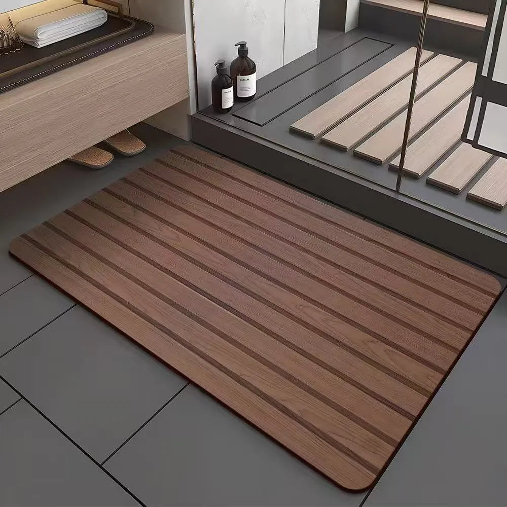 Square diatom mud bathroom floor mat with wood grain geometric pattern in front of a washroom door.