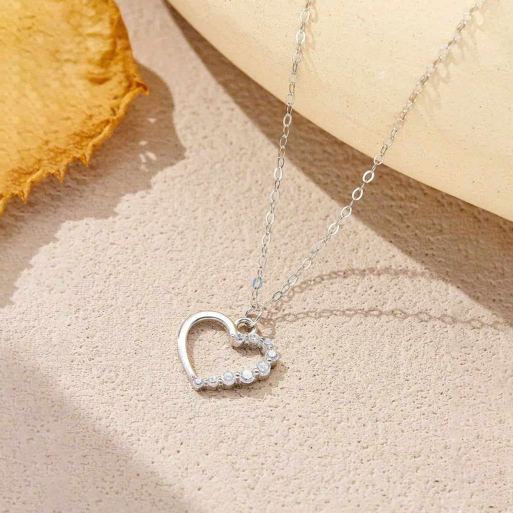 Close-up of a sterling silver hollow heart pendant necklace on a regular chain.