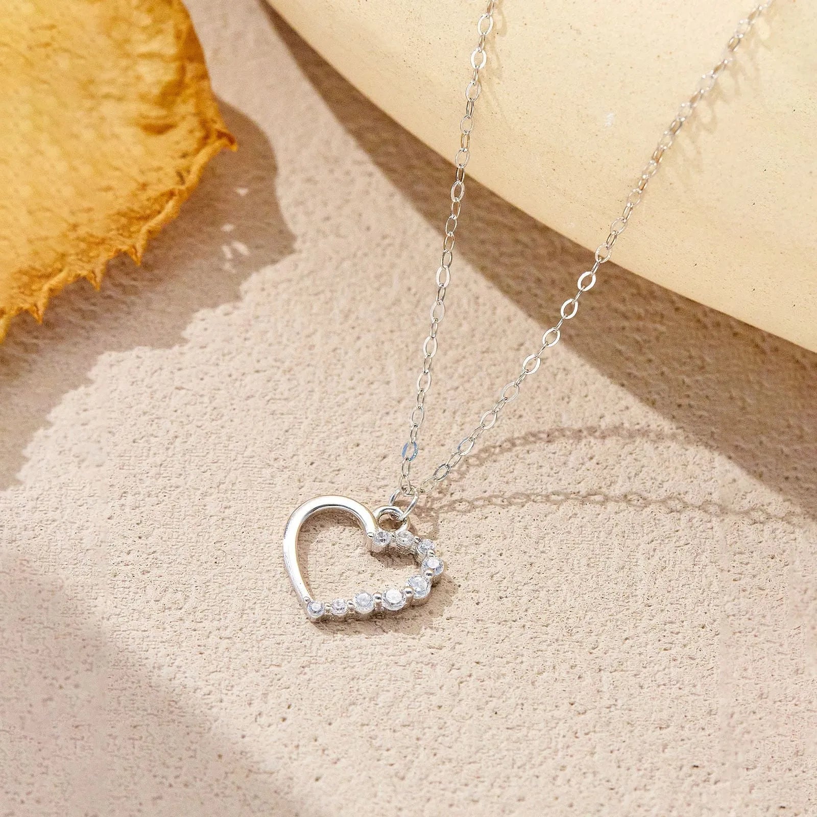 Close-up of a sterling silver hollow heart pendant necklace on a regular chain.