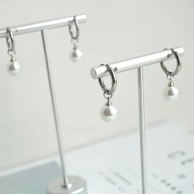 Pair of women's geometric pearl earrings with alloy construction and titanium steel posts