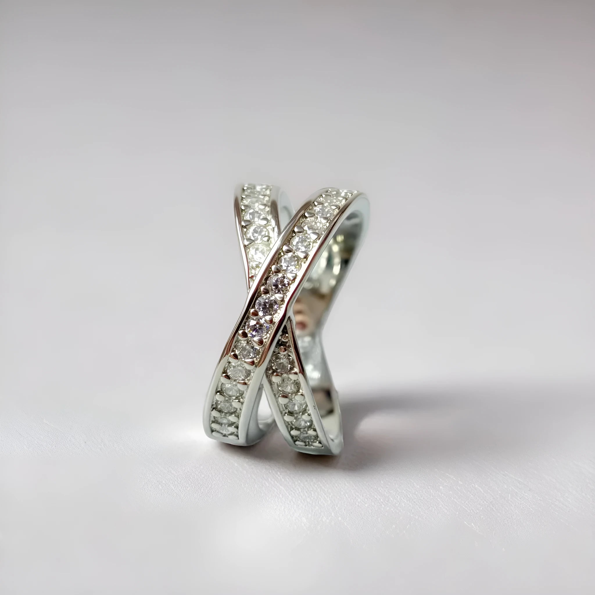 Silver and rose gold metal ring with a small cross design featuring micro-inlaid zircon stones.