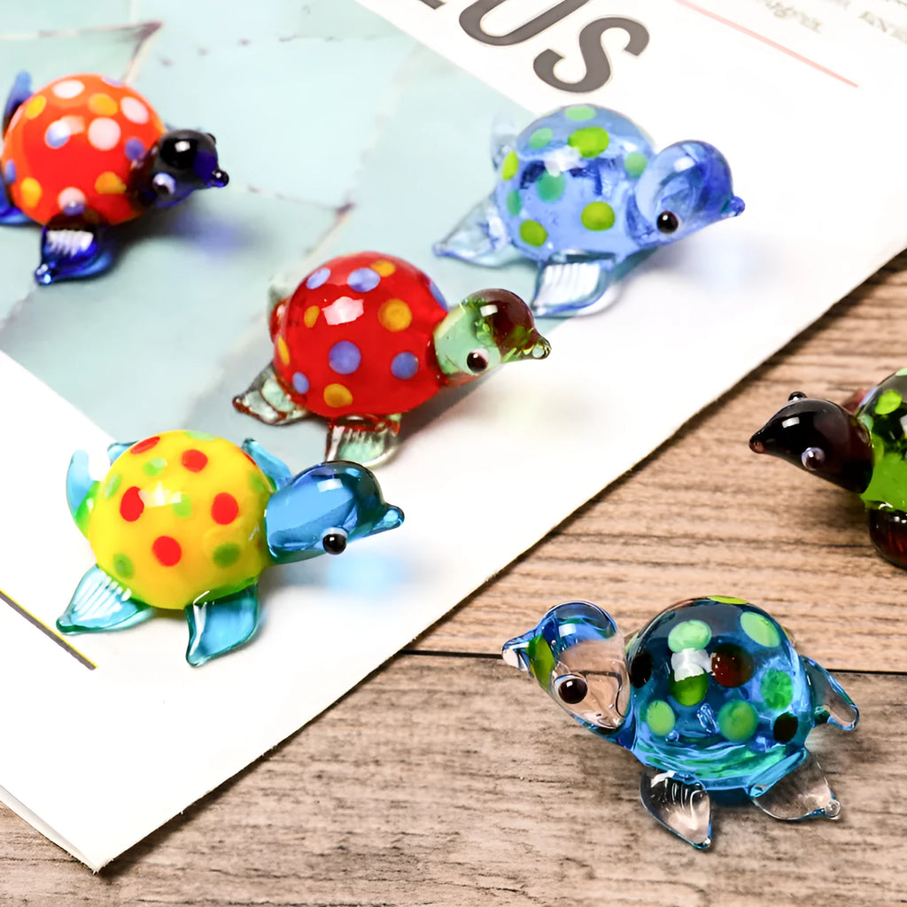 Geometric glass turtle ornament in a blue head and blue shell colour variant on a desktop.