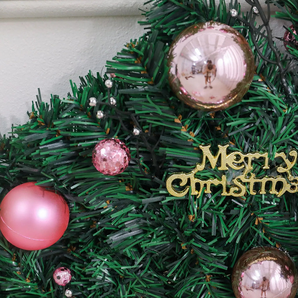 2.7 metre pink Christmas rattan garland with small fruit details and LED string lights displayed along mantelpiece
