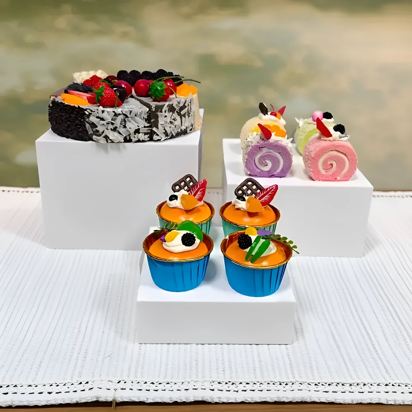 Set of six white plastic cube-shaped dessert display stands arranged on a desktop.