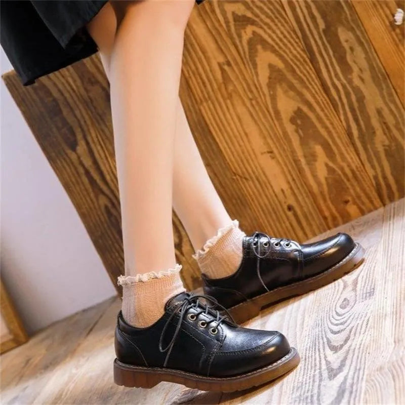 Women's preppy style brown retro Mary Jane pumps with round toe and front lace-up closure on a white background.