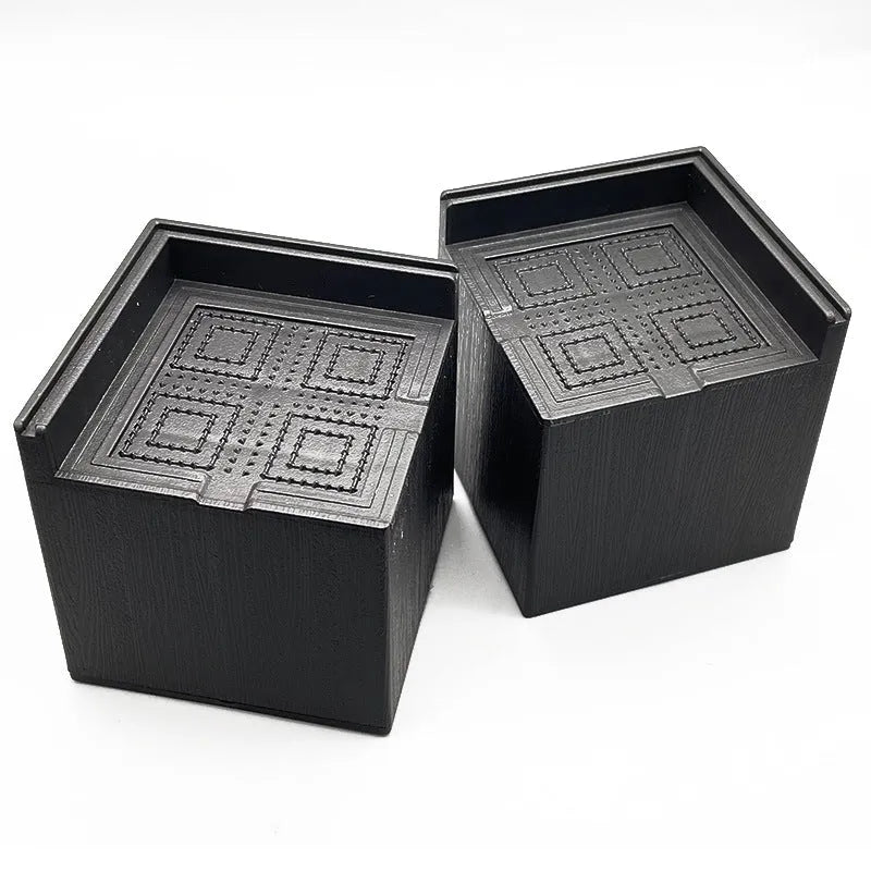 Four black plastic furniture foot mats for height adjustment of bed and sofa legs